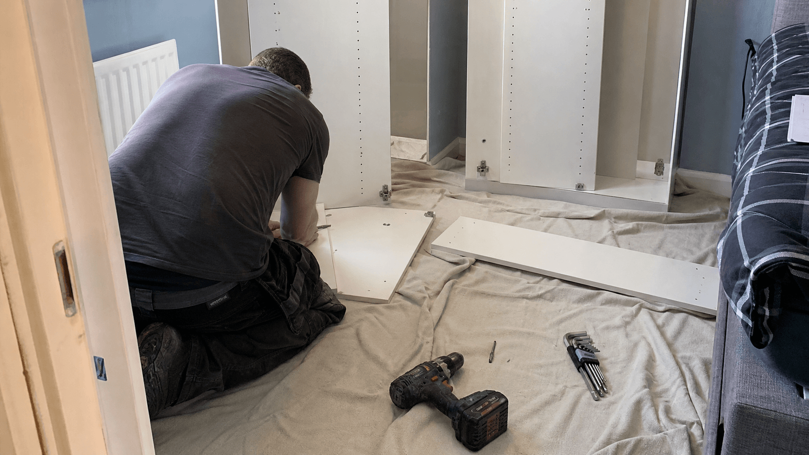 Handyman assembling a flat pack wardrobe in a bedroom